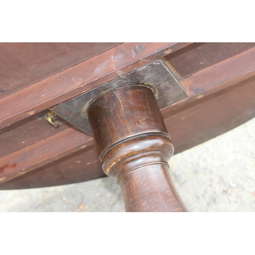 30 - An antique mahogany tilt topped table with tripod base, approx 89cm diameter x 74cm tall