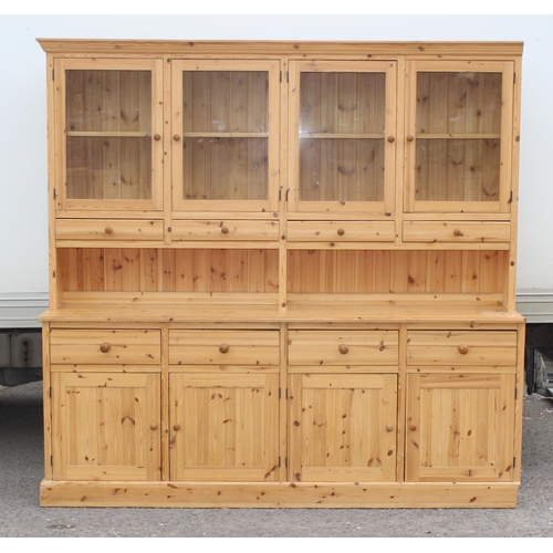 59 - A large glazed pine dresser with 4 cupboards to base, approx 230cm wide x 52cm deep x 221cm tall