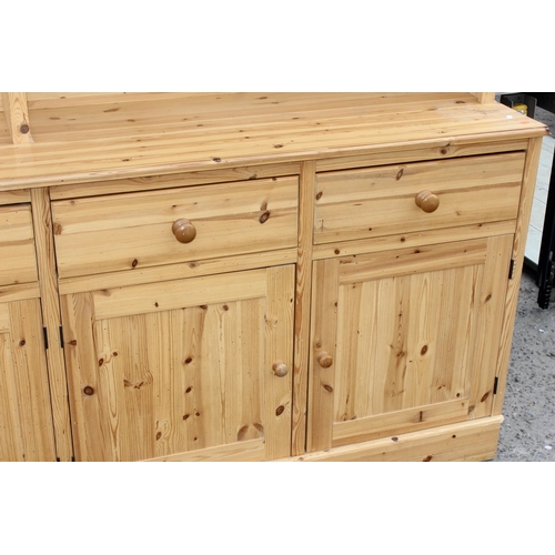 59 - A large glazed pine dresser with 4 cupboards to base, approx 230cm wide x 52cm deep x 221cm tall