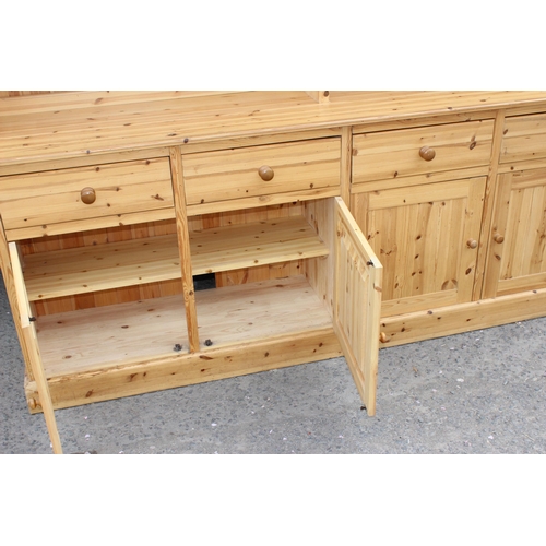 59 - A large glazed pine dresser with 4 cupboards to base, approx 230cm wide x 52cm deep x 221cm tall