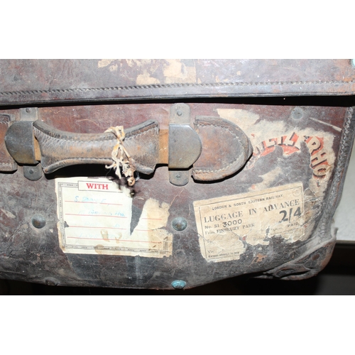 82 - A vintage leather travel trunk with a large number of period labels, by A. Boswell of Edinburgh, app... 