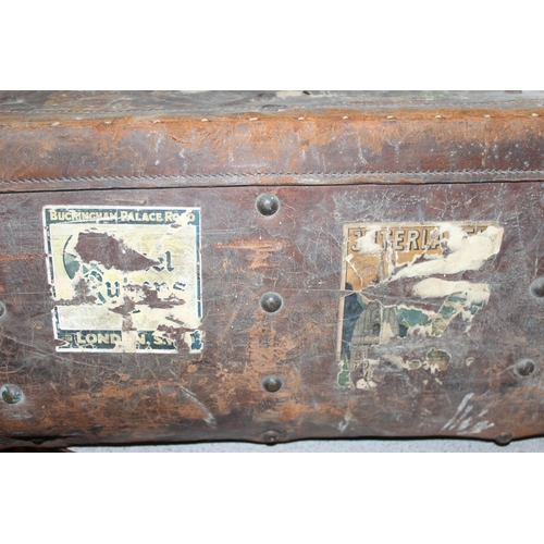 82 - A vintage leather travel trunk with a large number of period labels, by A. Boswell of Edinburgh, app... 