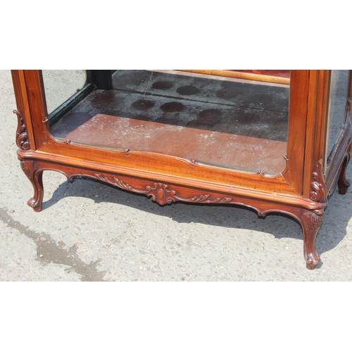 89 - A Continental carved mahogany display cabinet with velvet lines shelves and mirrored back, likely 19... 