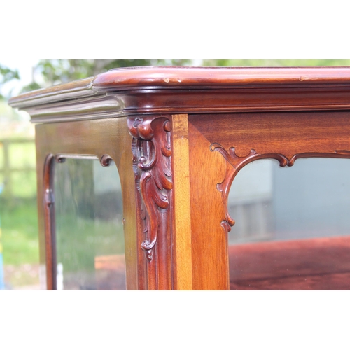 89 - A Continental carved mahogany display cabinet with velvet lines shelves and mirrored back, likely 19... 