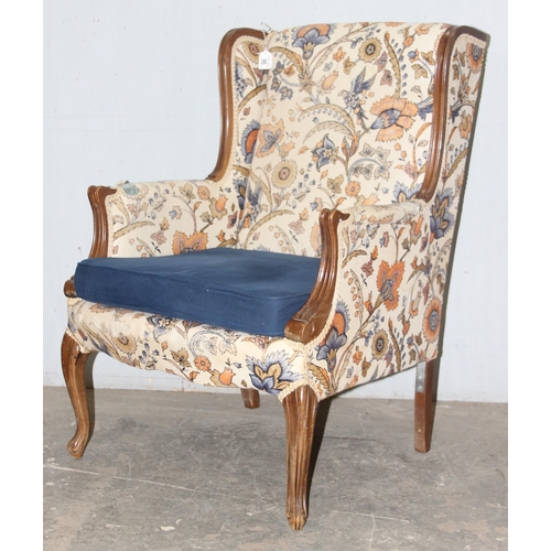 96 - An antique wingback armchair with wooden frame and William Morris style upholstery