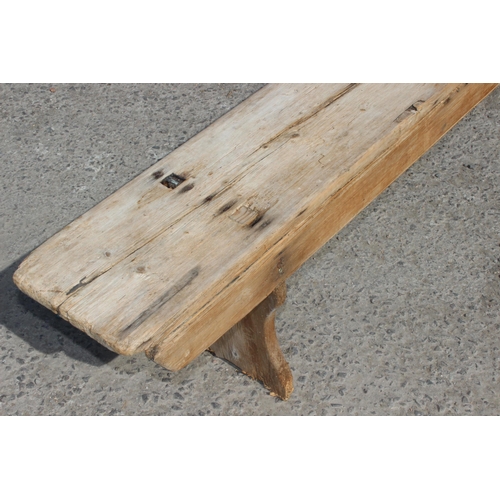 121 - A long rustic pine low bench, approx 255cm wide x 28cm deep x 39cm tall