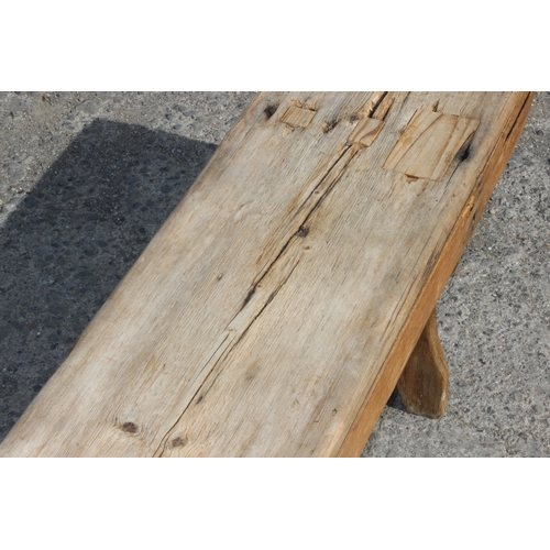 121 - A long rustic pine low bench, approx 255cm wide x 28cm deep x 39cm tall