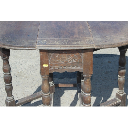 125 - A small antique oak drop leaf table with carved details, approx 77cm wide x 35cm deep (105cm fully e... 