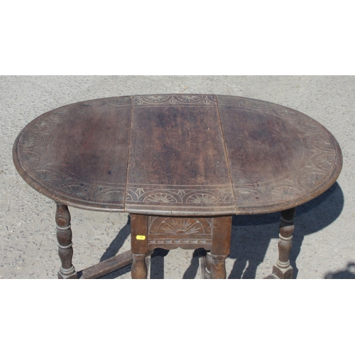 125 - A small antique oak drop leaf table with carved details, approx 77cm wide x 35cm deep (105cm fully e... 