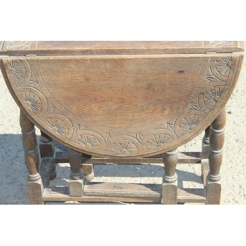 125 - A small antique oak drop leaf table with carved details, approx 77cm wide x 35cm deep (105cm fully e... 