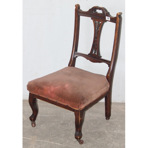 142 - An antique low or nursing chair with upholstered seat and carved details, approx 80cm tall