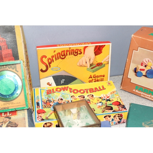 1544 - Box of vintage board and other games to include blow football, spring rings and a parachute fighter