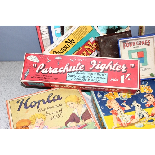 1544 - Box of vintage board and other games to include blow football, spring rings and a parachute fighter