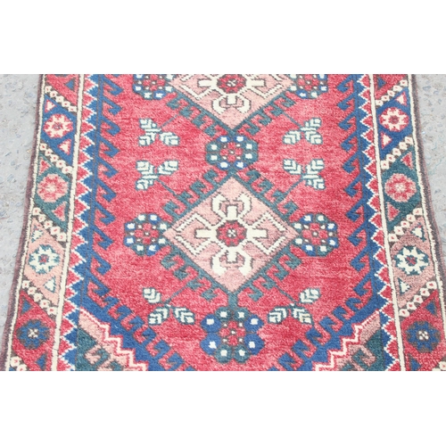 203 - Vintage hall runner rug of red ground, possibly Kurdish, approx 335cm x 80cm