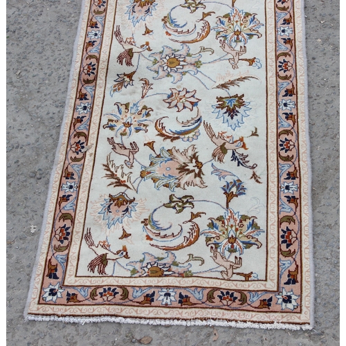 213 - A decorative cream ground runner rug with Arabesque border, approx 295cm x 85cm