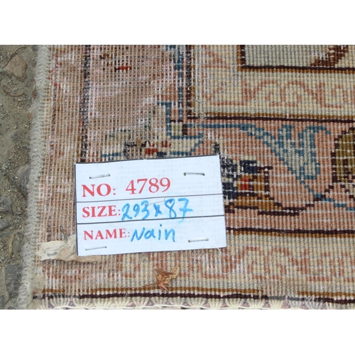 213 - A decorative cream ground runner rug with Arabesque border, approx 295cm x 85cm