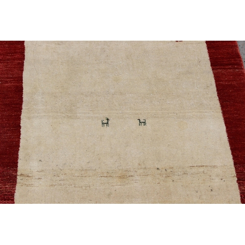 216 - An unusual cream ground rug with red border, decorated with animals, approx 200cm x 153 cm