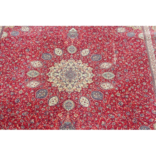 219 - A large Persian style highly decorative red ground rug, approx 320cm x 275cm