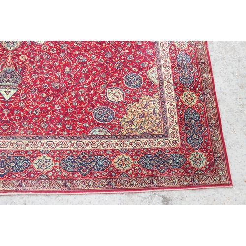 219 - A large Persian style highly decorative red ground rug, approx 320cm x 275cm