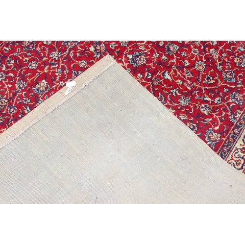 219 - A large Persian style highly decorative red ground rug, approx 320cm x 275cm