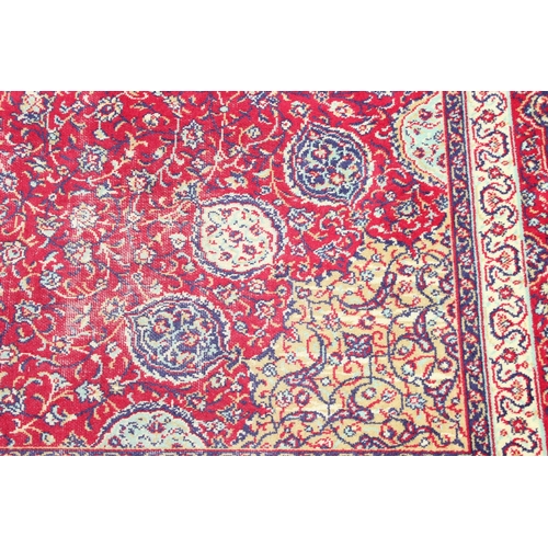 219 - A large Persian style highly decorative red ground rug, approx 320cm x 275cm