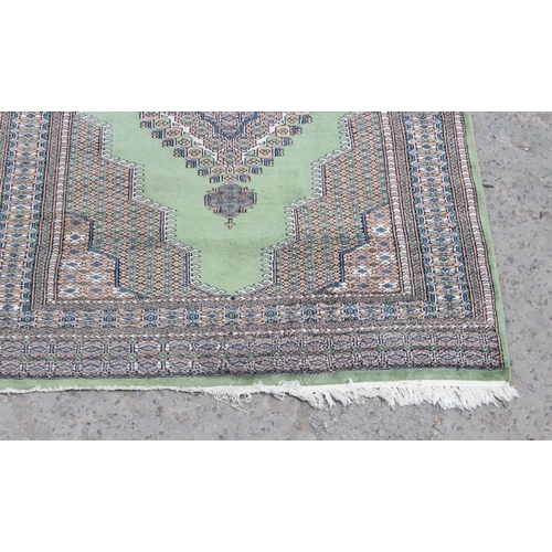 221 - A large decorative green and patterned Persian style rug, approx 210cm x 123cm