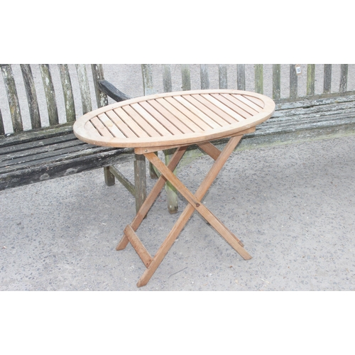 325 - 2 weathered teak weathered garden benches and a folding teak table, largest approx 150cm W x 85cm H ... 