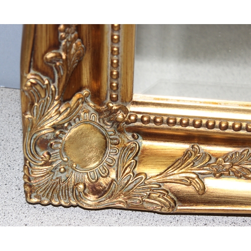 442 - Gilt framed wall mirror with classical decoration, approx 90cm x 65cm