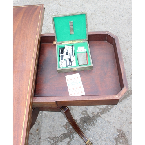 170 - An antique mahogany card table with fold over top, baize lined interior and  games, approx 90cm wide... 