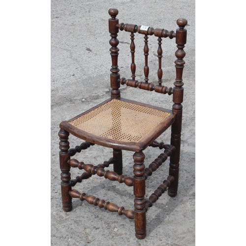 172 - An Arts & Crafts period oak chair with decorative turned supports and bergere seat, approx 90cm tall