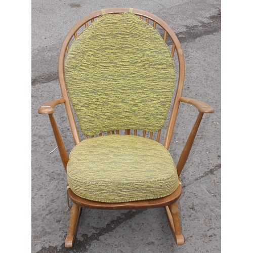 3 - A vintage blonde Ercol rocking chair with stick back and cushions, original blue & gold label, appro... 