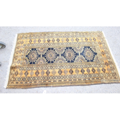 224 - A vintage yellow and dark blue ground hand made Persian rug, approx 173cm x 107cm