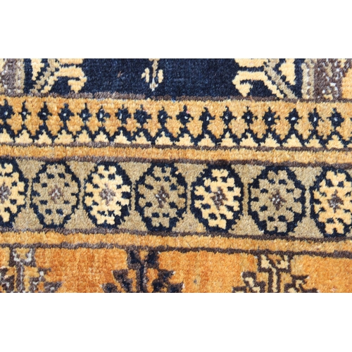 224 - A vintage yellow and dark blue ground hand made Persian rug, approx 173cm x 107cm