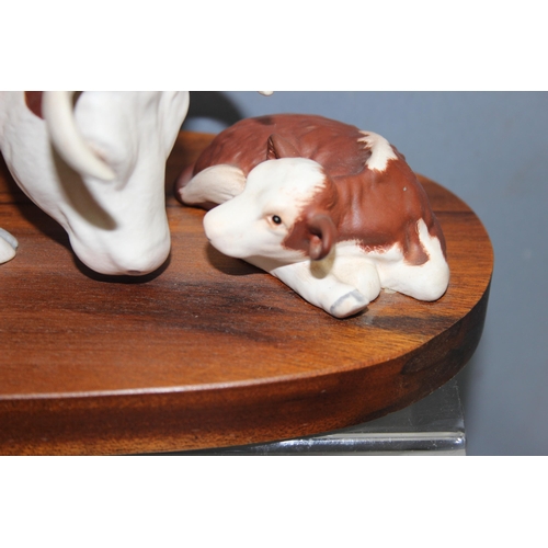 1602 - Beswick pottery, a large pottery model of a cow and calf on wooden base, approx 34cm wide, matt fini... 