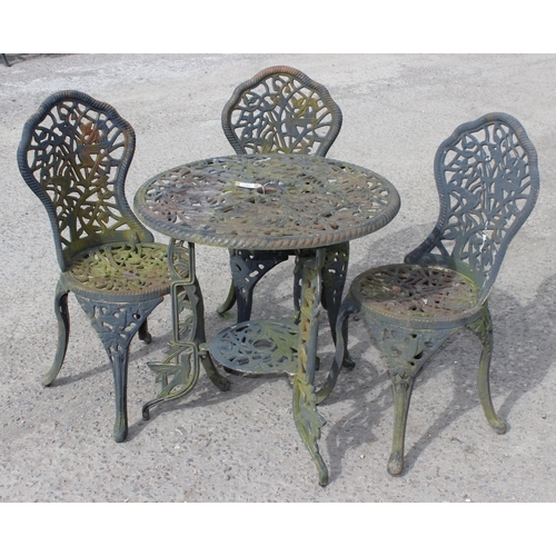 387 - A Victorian style cast iron garden table and 3 chairs, table approx 70cm diameter x 71cm tall