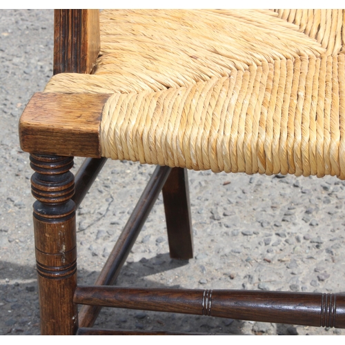 193 - Oak rush seated Arts & Crafts period carver chair with interesting carved detail