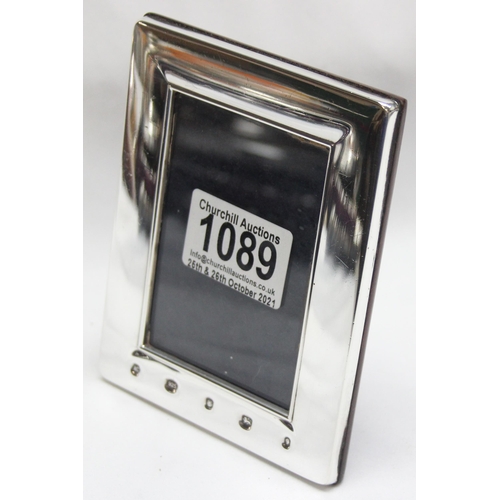 1089 - A plain silver photograph frame with prominent hallmarks and easel back, marked for Sheffield 2002, ... 