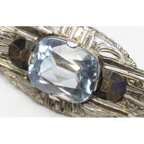 1110E - An interesting 18ct white gold and blue stone brooch, possibly an aquamarine, assessed as approx 7ct... 