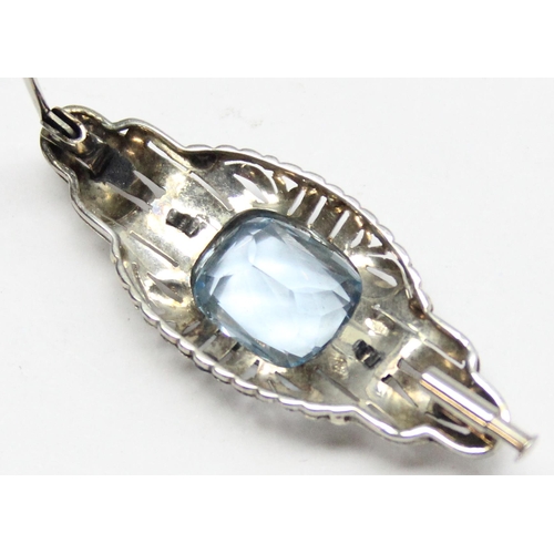 1110E - An interesting 18ct white gold and blue stone brooch, possibly an aquamarine, assessed as approx 7ct... 