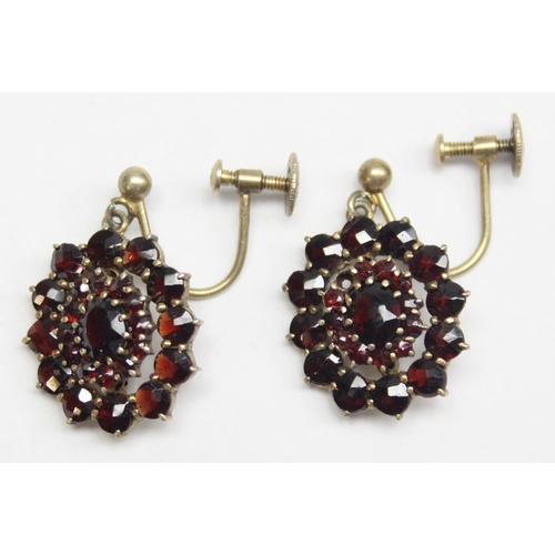 1196 - A pair of silver gilt and floral set garnet coloured red stone earrings with screw fittings, marked ... 