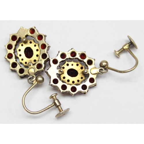 1196 - A pair of silver gilt and floral set garnet coloured red stone earrings with screw fittings, marked ... 