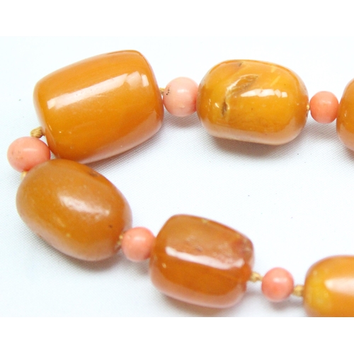 1198 - A vintage Amber bead necklace, a mixture of oval and cylindrical beads with alternate circular coral... 