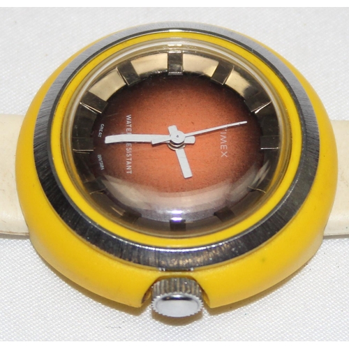 1346 - A retro Timex wrist watch with yellow plastic and stainless steel case and cream vinyl strap, the ca... 