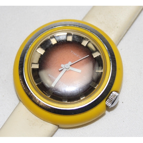 1346 - A retro Timex wrist watch with yellow plastic and stainless steel case and cream vinyl strap, the ca... 