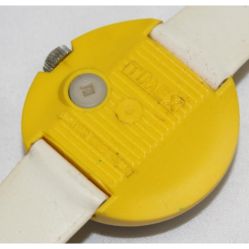 1346 - A retro Timex wrist watch with yellow plastic and stainless steel case and cream vinyl strap, the ca... 