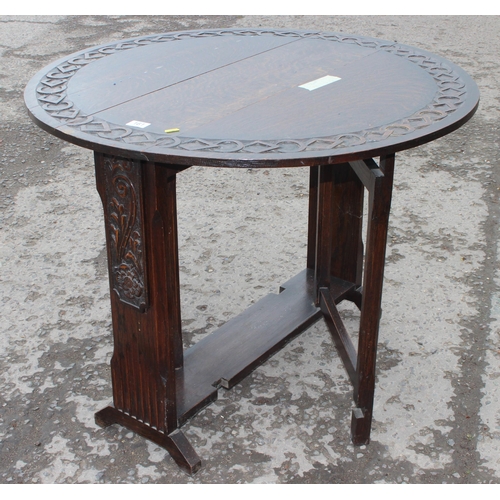 161 - An antique style oak drop leaf table with carved details, approx 90cm wide x 92cm deep x 71cm tall w... 