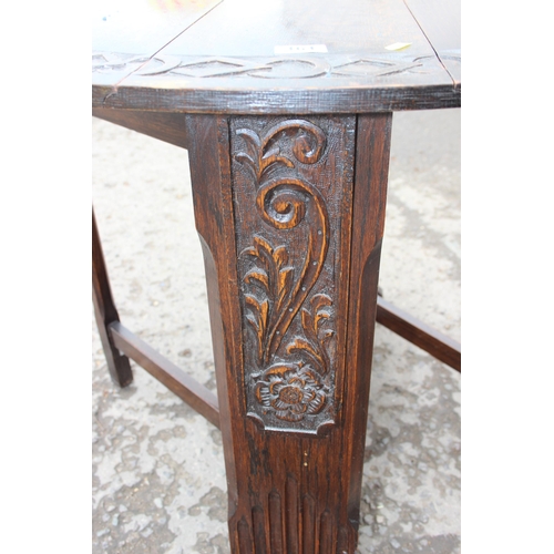 161 - An antique style oak drop leaf table with carved details, approx 90cm wide x 92cm deep x 71cm tall w... 