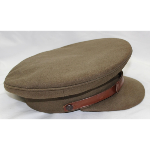 1403 - A vintage military officer's cap with Cambridgeshire Regiment badge, a WW2 or earlier period leather... 