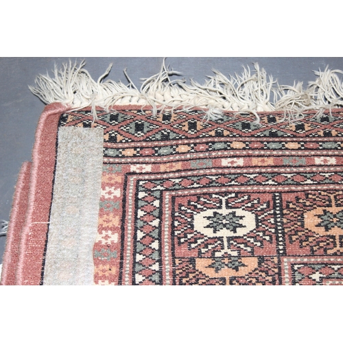 200 - A vintage Bokhara style rug of salmon ground, approx 180cm x 131cm