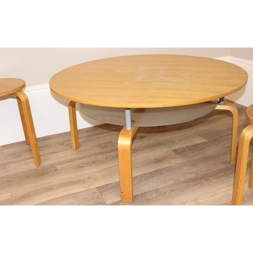 78 - A Scandinavian style round low table with glass undertier, and a pair of similar lightwood stools wi... 